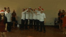 a group of people are wearing santa hats and holding hands