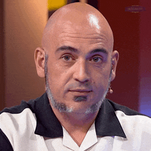 a bald man with a beard and mustache looks at the camera with a microphone in front of him that says passmaster