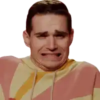 a man in a pink and yellow striped hoodie makes a funny face