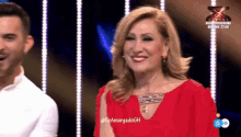 a woman in a red dress is smiling in front of a man in a white shirt ..