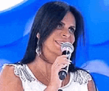 a woman is smiling while holding a microphone .