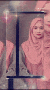 a woman in a pink hijab is displayed on a cell phone