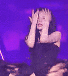 a woman in a red dress is dancing on a stage in front of a pink background .