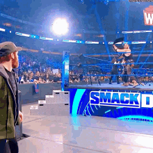 a man stands in front of a sign that says smack down