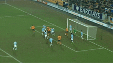 a soccer field with a barclays banner on the side