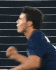 a man in a blue shirt is screaming in a blurry photo .