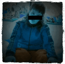 a person wearing a blue adidas jacket with a black stripe on the side