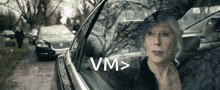 a woman is looking out of a car window with vm > written on it