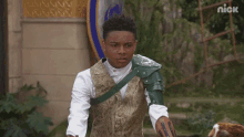 a young man in a knight costume is standing in front of a sign that says nick on it