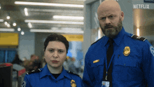 a man and a woman in blue uniforms are standing next to each other with a netflix logo behind them