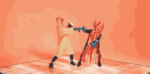 a person dressed as bacon is boxing another person dressed as a chicken