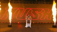 a wrestler in a viking costume is standing in front of a sign that says rush