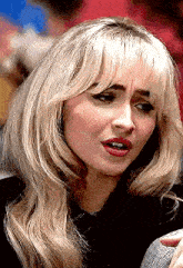 a close up of a woman with blonde hair making a funny face .