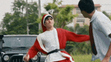 a man in a santa suit is standing next to another man in a white shirt and tie .