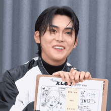 a young man is holding a clipboard that says xlc j on it