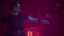 a woman is dancing in a dark room with red lights