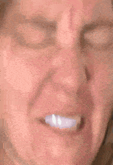 a close up of a woman 's face with her eyes closed and a smile on her face