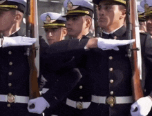 a group of men in military uniforms holding guns in a line