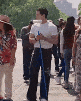 a man in a white t-shirt is holding a blue mop