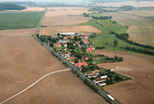 an aerial view of a small village surrounded by fields and houses