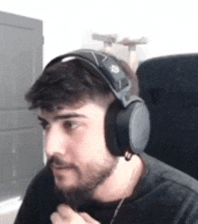 a man with a beard wearing headphones and a black shirt