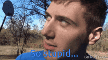 a man in a blue shirt says " so stupid " in blue letters
