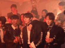 a group of people are gathered in a room with a man wearing a jacket that says radio wave on the sleeve