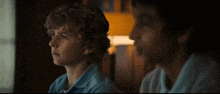 two young men are sitting next to each other in a room