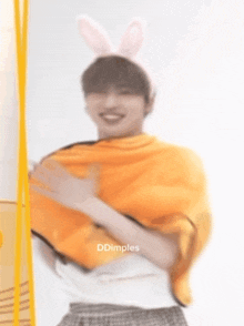 a blurry picture of a man wearing bunny ears and a yellow blanket .