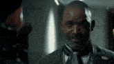 a man wearing a suit and tie has a pin on his lapel that says ' united states of america '