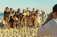 a man taking a picture of a group of people on a beach