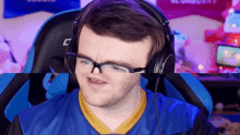 a man wearing glasses and headphones is sitting in a blue chair