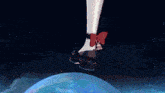 a woman 's leg with a red bow is standing on a blue bubble
