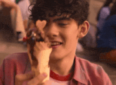 a young man with curly hair is eating ice cream