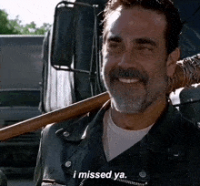a man with a beard is smiling and holding a bat and says i missed ya