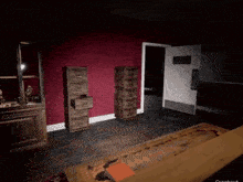 a room with a red wall and a wooden floor