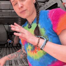 a woman wearing a colorful tie dye shirt with the word santa on it