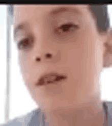 a close up of a young boy 's face with a blurred background .