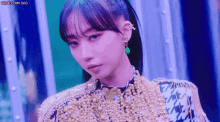 a close up of a woman wearing a purple and gold outfit