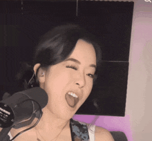 a woman is smiling in front of a microphone