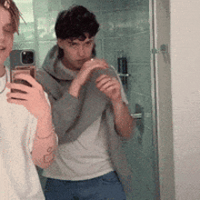two people are taking a selfie in front of a mirror