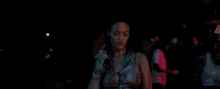 a woman is holding a gun in a nightclub while money is falling from the ceiling .