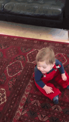 a baby is crawling on a rug with a couch in the background