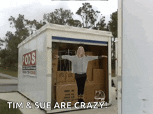a woman stands in front of a pods moving truck