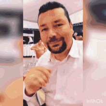a man with a beard is sitting at a table with a glass of wine in front of him