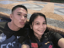 a man and woman are posing for a picture and the man is wearing a shirt that says ccc on it