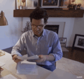 a man sitting at a desk looking at a piece of paper with suds95 written on the bottom