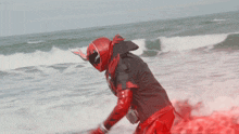a person in a red helmet is riding a wave