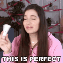 a woman in a pink sweatshirt holds a remote control and says this is perfect