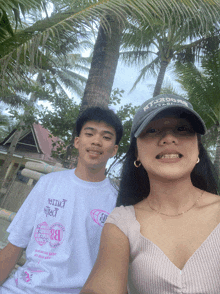 a man and a woman are posing for a picture and the man is wearing a hat that says ' abercrombie '